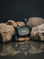 BOYA microphone and receiver on rocks with a dark background
