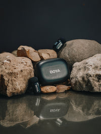 BOYA microphone and receiver on rocks with a dark background