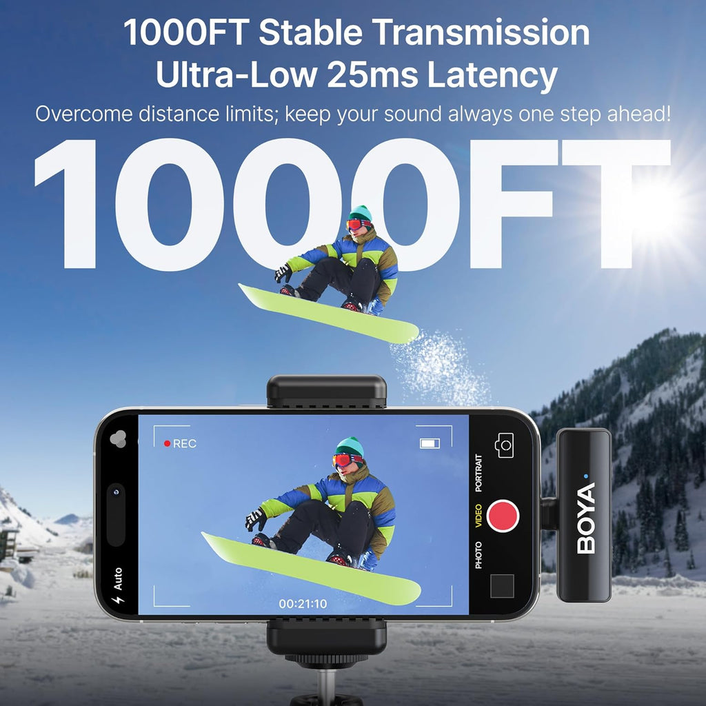 Snowboarder on a snowboard with a smartphone and BOYA microphone in a mountainous winter setting.