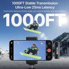 Snowboarder on a snowboard with a smartphone and BOYA microphone in a mountainous winter setting.