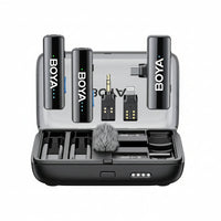 BOYALINK 2 wireless lavalier microphone set with various accessories including charging case, wind cover, and adapters displayed open on a table.