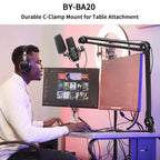 Person using a computer with a microphone and monitor setup, featuring a BY-BA20 durable C-clamp mount.